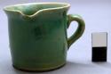 Miniature handled pouring cup, green glazed ceramic