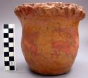 Red ceramic jar with a partial yellow glaze. Ribbed unpressed decoration around