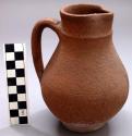 Red earthenware pitcher with cover.