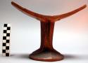 Headrest, carved wood, concave seat, grooved pedestal, pigment stripes