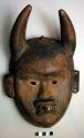 Poro mask, wood, open mouth has one tooth, with sockets for others which are mis