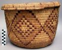 One large coiled wave basket with cover.  brown and yellow designs