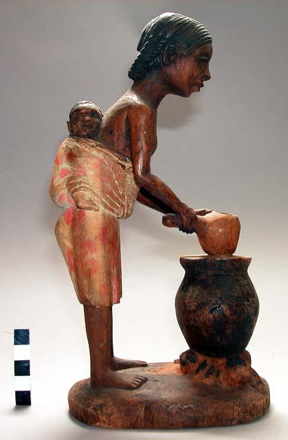 Wood carving of woman with baby on back