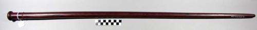 Staff, carved wood, cylindrical shaft tapered to blunt end, discoidal knob