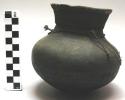Small pottery washing pot, black, incised decorations, fibre thong around neck (