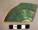 Potsherd - base of bowl, green glaze on red clay