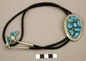 Bolo, oval silver base with a grooved rim, set with 8 turquoise nuggets