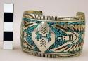 Cuff bracelet, wide silver band inlaid with stones forming thunderbird design