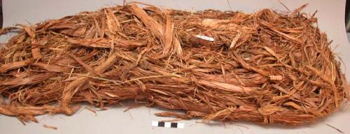 Part of cedar bark cradle or bag filled with grass
