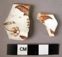 2 rim potsherds - red-brown on white glaze