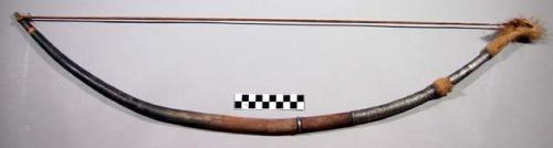 Bow, carved wood, covered with skin and metal wraps, fur decoration