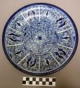 Plate on raised (1 cm) base, buff clay, white glaze and dark blue border & geome