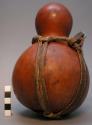 Gourd container, leather and bast carrying strap, incised decoration at rim 7 3/