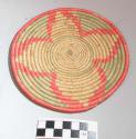Small basketry plate, coiled weave, four leaf pattern in crimson and green (luga