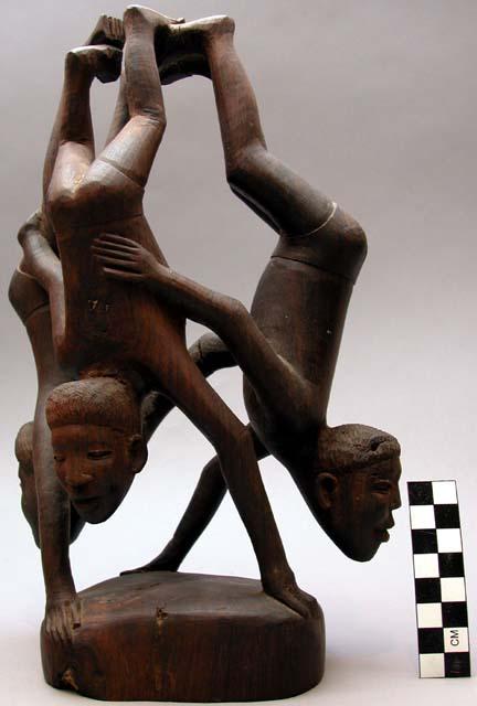 Sculpture of three upside-down human figures