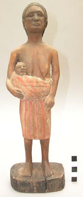 Wood carving of woman with child in front of dress