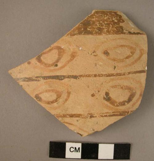 Ceramic rim sherd, buff ware with brown painted concentric ovals