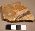Piece of thin sandstone painted red and black