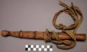 Sheath containing knife - hand hewn, decorated with rings of braided fibre cloth