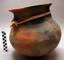 Pottery water pot, reddish brown, incised decoration around neck, also a grass t
