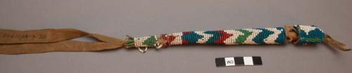 Awl with beaded leather case. Zig-zag design, beads threaded on natural fibre