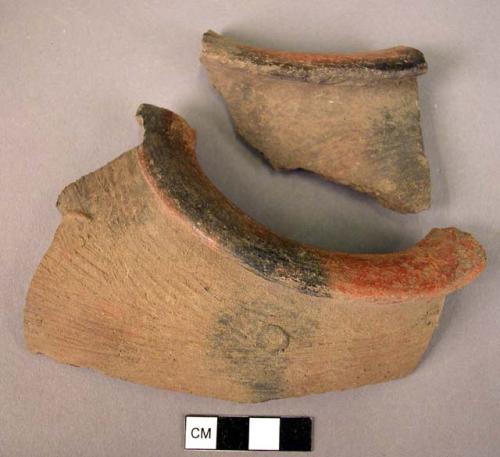 Ceramic sherds from shoe-shaped vessel, black ware, red rim, textured surface