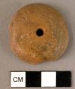 Disk-shaped amber pendant, flattened on one side and cross-drilled