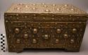 Large wooden box covered with metal, elaborate design with protruding knobs