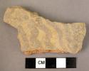 Ceramic body sherd, buff ware w. black painted curvilinear design.