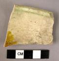 Rim potsherd- cream, green, yellow glaze