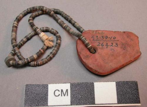 String of flat shell beads with red stone pendant