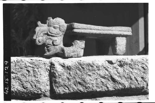 Metate with a face in the jaws of an animal