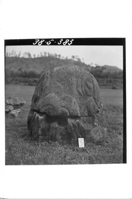 Stone figure (head missing) deliniated upon a boulder (Back)