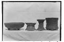 From left to right: clay tripod bowl with recurved sides - two clay pot stands -