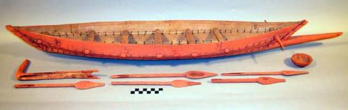Model, canoe, 5 paddles, 1 bowl, and rudder? painted orange, sewn