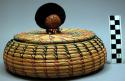 Coiled bowl-shaped basket (A), with lid (B), representing Seminole woman