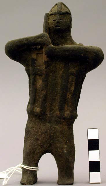 Clay figure holding object at shoulder