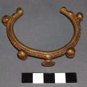 Brass bracelet, rope like pattern, with bulbous knobs at intervals and flat-head