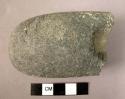 Ground stone fragment, polished, thick rounded end, partially perforated