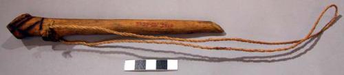 Whistle, tubular piece of wood, fibre attachment, linear pattern burned into woo