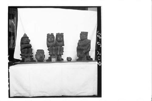 4 small stone figures (front); 1 small stone head (front); 1 small stone ring (f