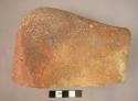 Quern or grinding stone stained with red ochre or haematite