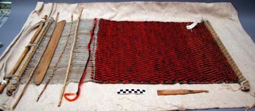 Small rug on loom; pattern in black and orange