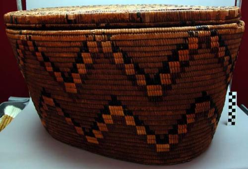 Coiled and imbricated cedar root oval basket (A) with lid (B)