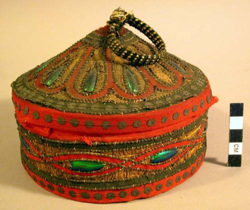 Circular box of straw covered with elaborate designs of red cloth, +