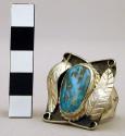 Ring, silver, turquoise stone in platform setting flanked by silver leaves