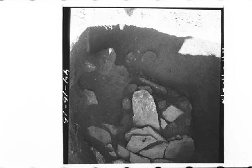 Pottery fragments along W edge of lajas among stones.  Photo towards E and down.