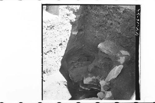 Pots 19-25, 27-31 in situ in NE portion of tomb cut, along edge of lajas.  From