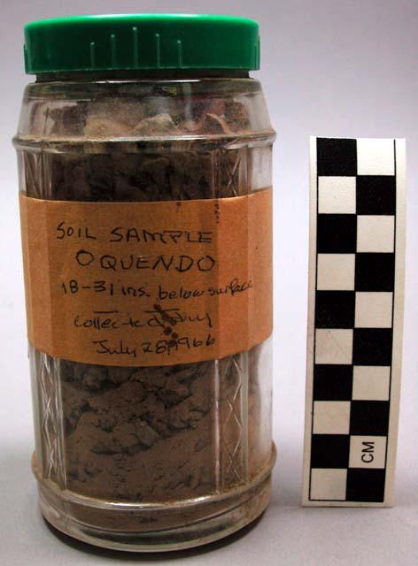 Chipped stone and soil sample in glass jar