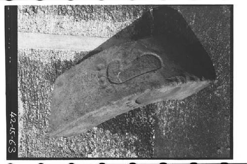 Fragment of stone yoke with sculptured imprints of human feet